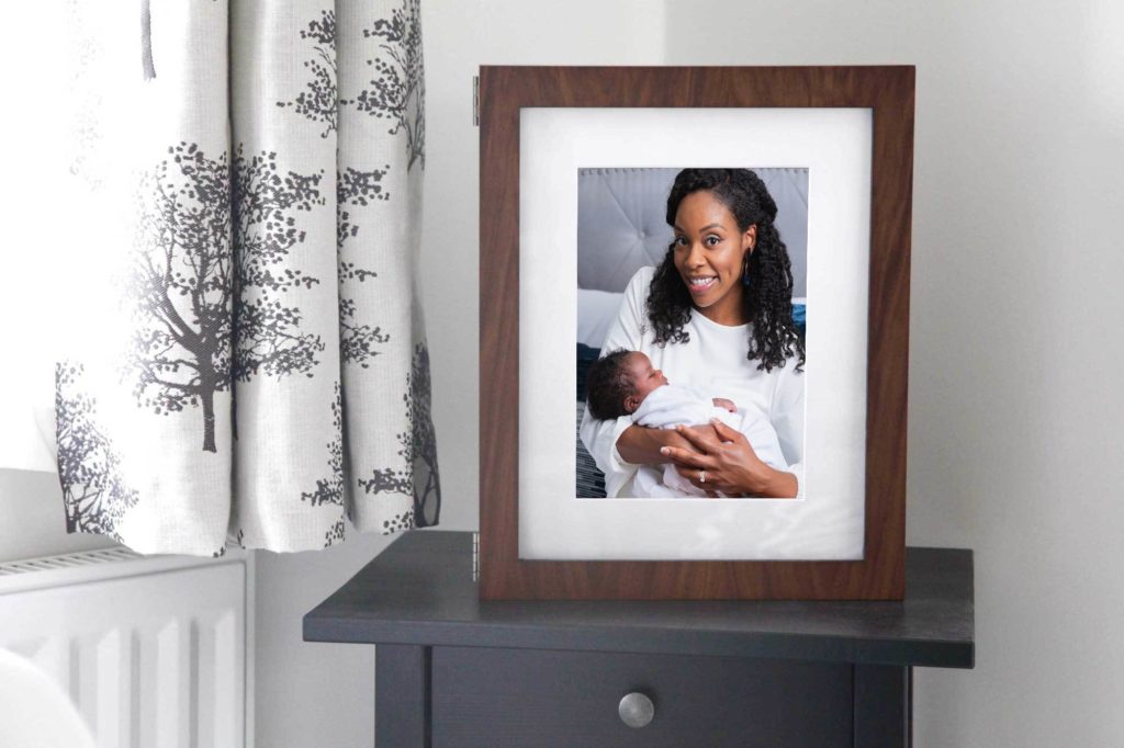 Shows printed family photos on a nightstand. 