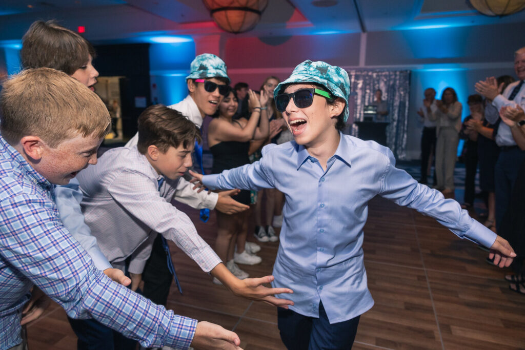 Bar mitzvah boy dancing with friends at bar mitzvah reception
