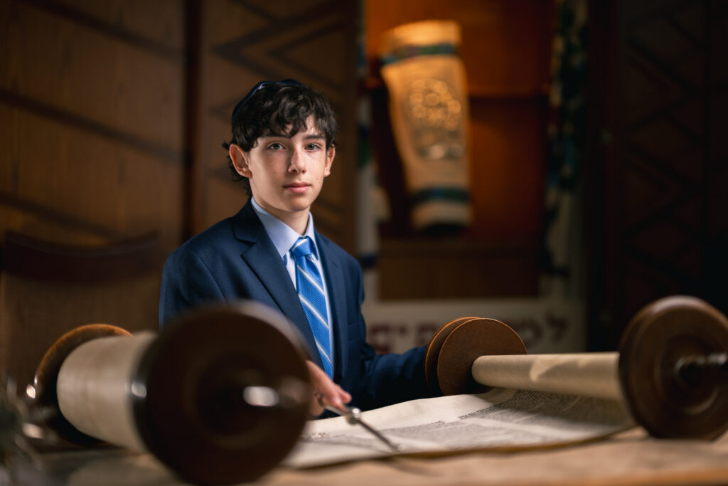 Bar mitzvah boy holding Torah scroll portrait