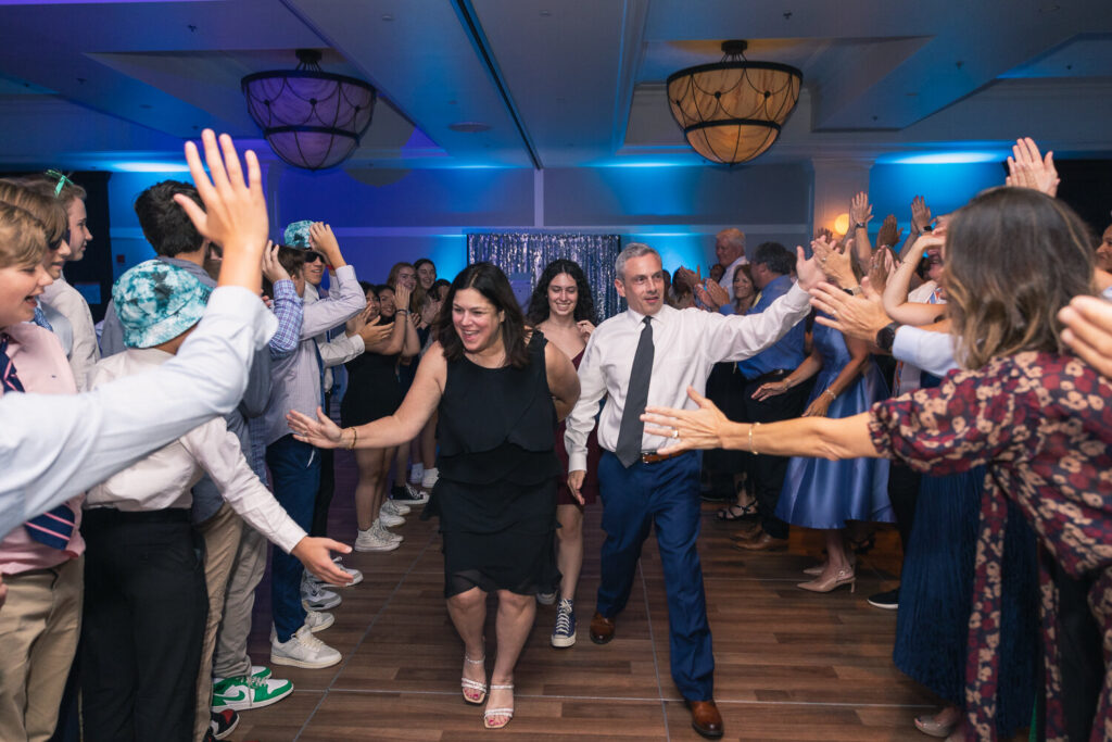 Parents walking through high-five tunnel at bar mitzvah reception